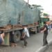 Bus Penumpang Pariwisata Laga Kambing Dengan Tronton Pengangkut Kayu Balok