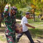 Dandim 1509/Labuha Letkol Inf Untung Prayitno SIP MHan memikul sembako sumbangan untuk warga miskin