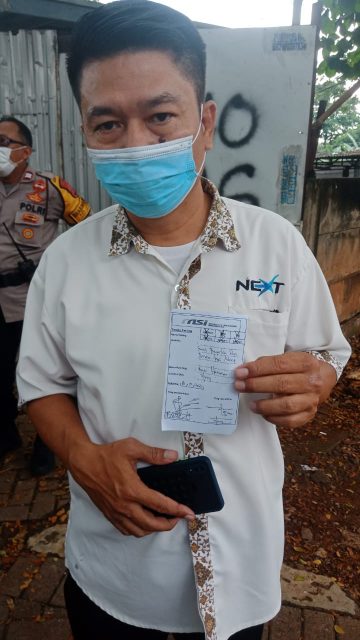 Koordinator aksi Budi H saat memegang bukti tanda terima surat tuntutan aksi ke pihak perusahaan Next Taksi