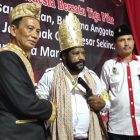 Tampak Guru Besar Sekinci-kinci Hasbullah gelar Tuan Raja Marga selaku Bapak dengan Dr Lenis Kogoya MHum selaku Anak saat acara penobatan Panglimo Perdamayan