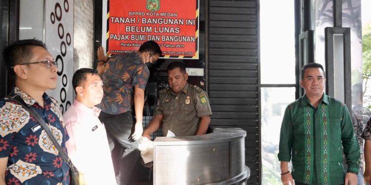 BPPRD Medan Pasang Stiker Spanduk Tunggakan PBB  di Hotel Grand Jamee